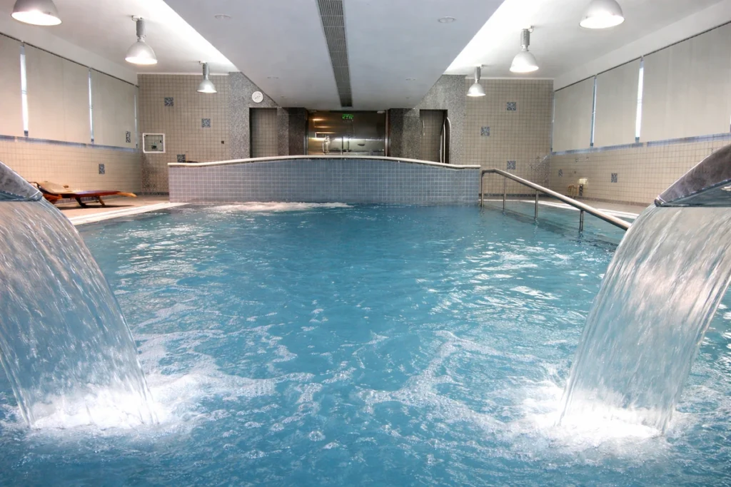 Indoor thermal pool with waterfall jets at Villa Termal das Caldas de Monchique Spa